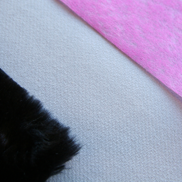 Détail nappe intissée grise set en fourrure et chemin de table rose