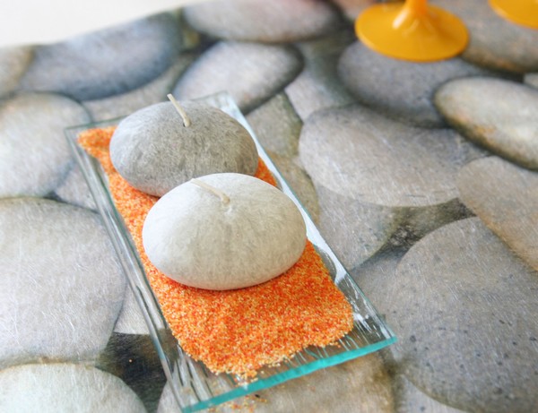 Petite assiette en verre, sable décoratif et bougies en forme de galets