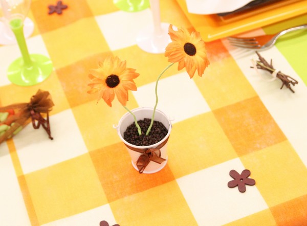 Composition à réaliser avec un petit seau, des granulés et une fleur